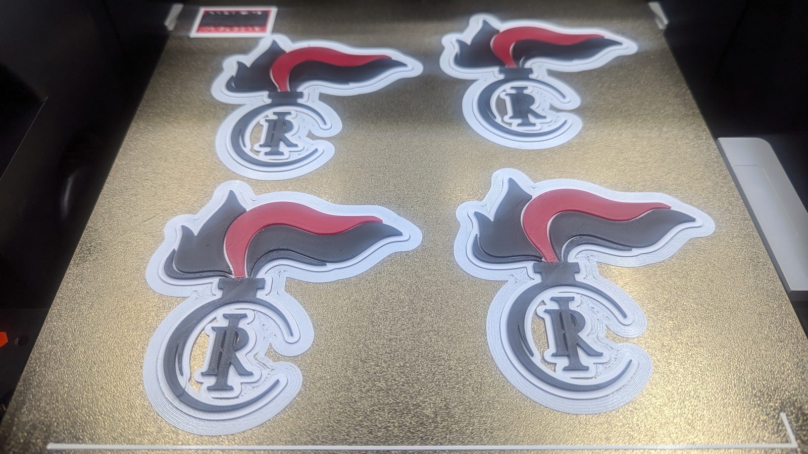 Vier identische Wappen-Embleme frisch gedruckt